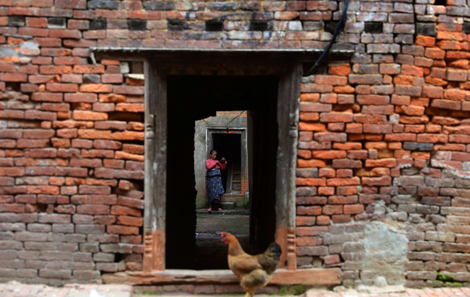 Nepali naine oma maja ees.
