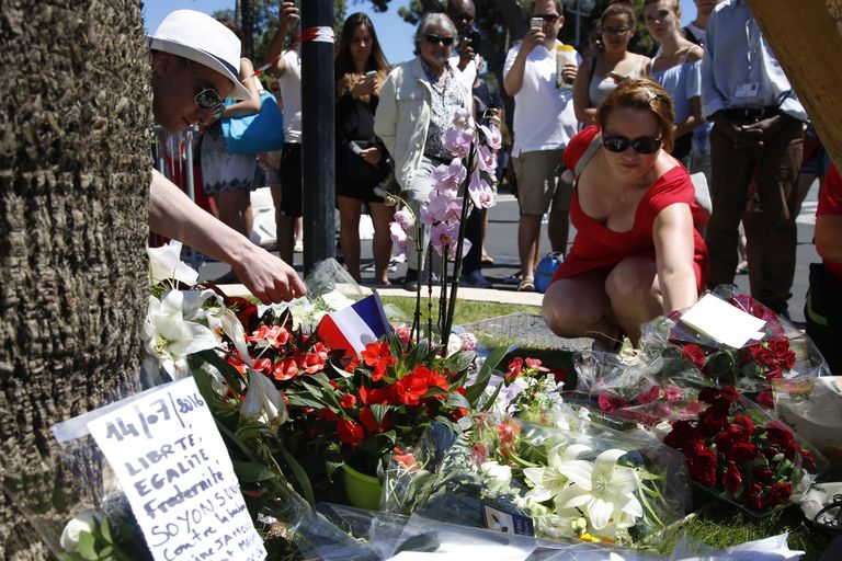 Inimesed asetamas sündmuspaiga lähedale lilli ja muid meeneid. Allikas: Scanpix