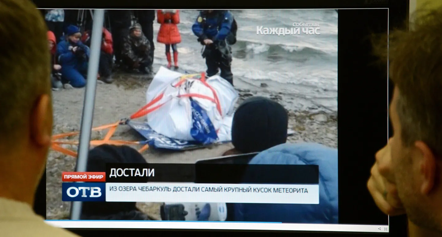 Mehed uurivad arvutiekraanilt fotot Tšeljabinski meteoriidi suurimast tükist.