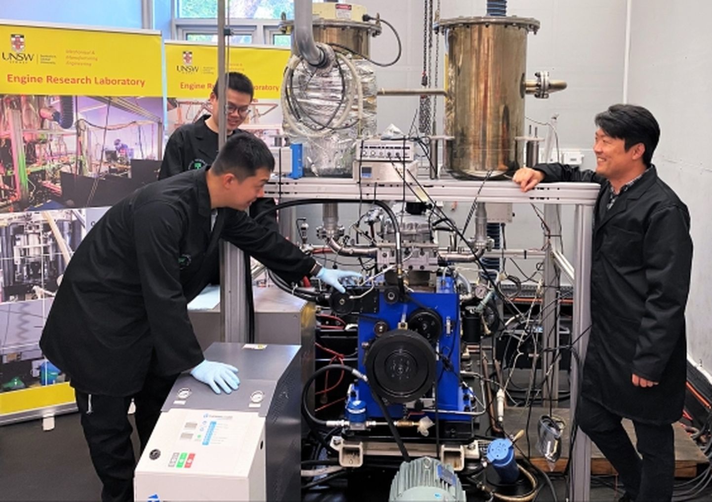 Diisel-vesiniku otsesissepritsega hübriidmootori loojad Uus Lõuna-Wales'i ülikoolist: professor Shawn Kook (paremal), Xinyu Liu (vasakul taga) ja Jinxin Yang.