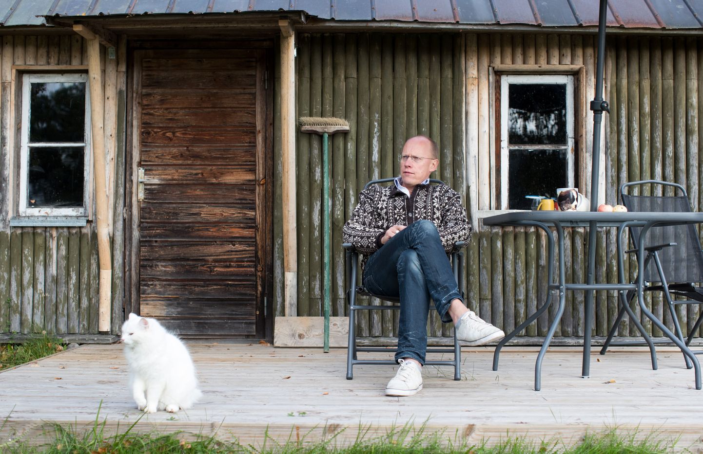 Ahto Lobjakas koos naabri kassiga oma sauna ees.