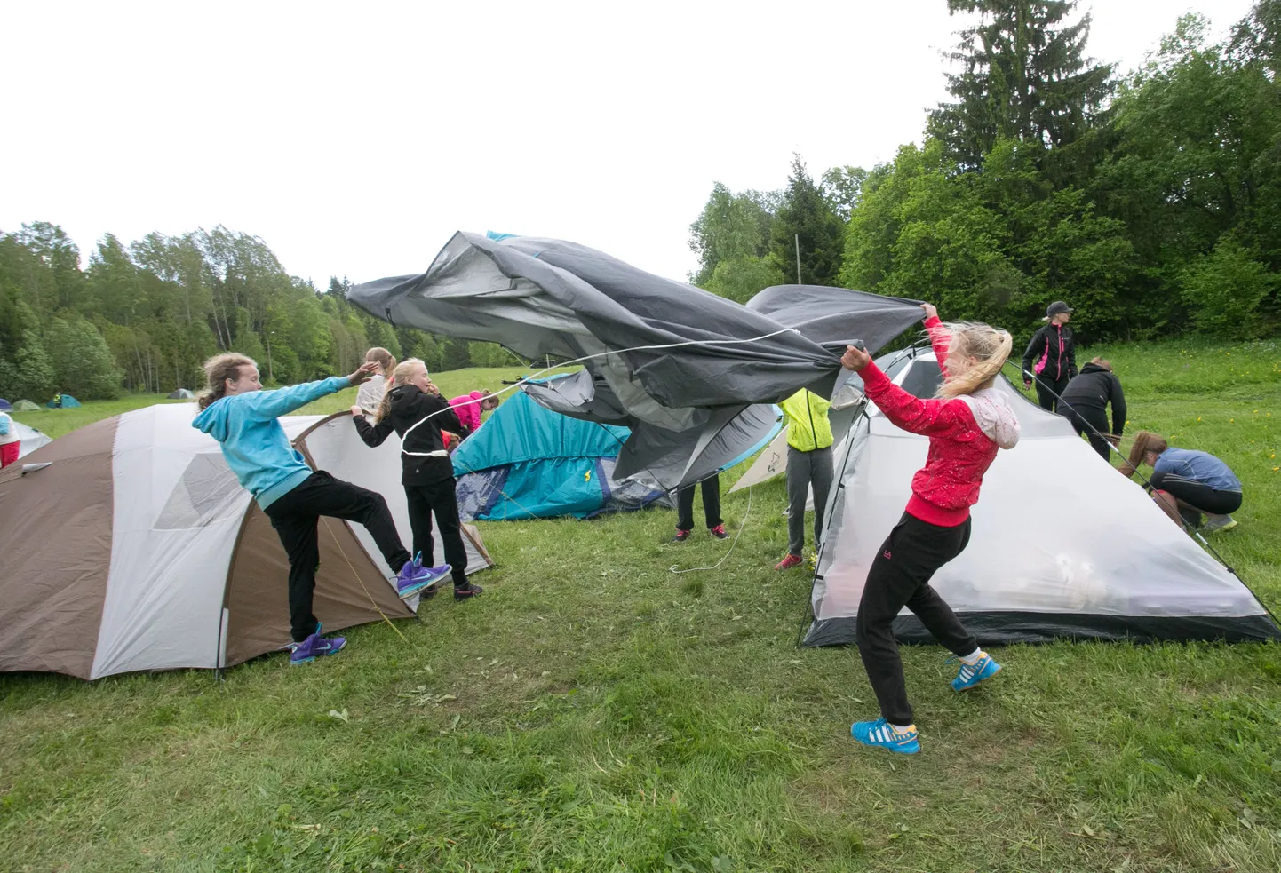 Kuidas panna üles telki, kui puhub tuul 20 m/s ? Fotol päästelaager Pariisi puhkekülas.