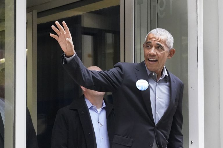 Бывший президент Барак Обама машет рукой толпе после того как проголосовал на участке досрочного голосования в понедельник, 17 октября 2022 года, в Чикаго.