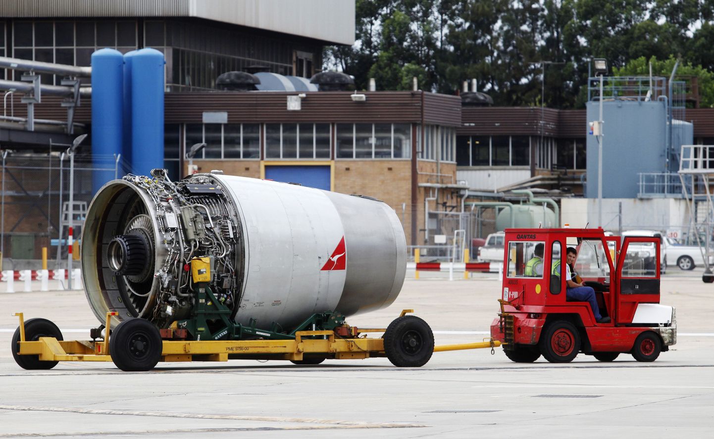 Qantase töölised transpordivad lennuki mootorit Sydney lennuväljal.
