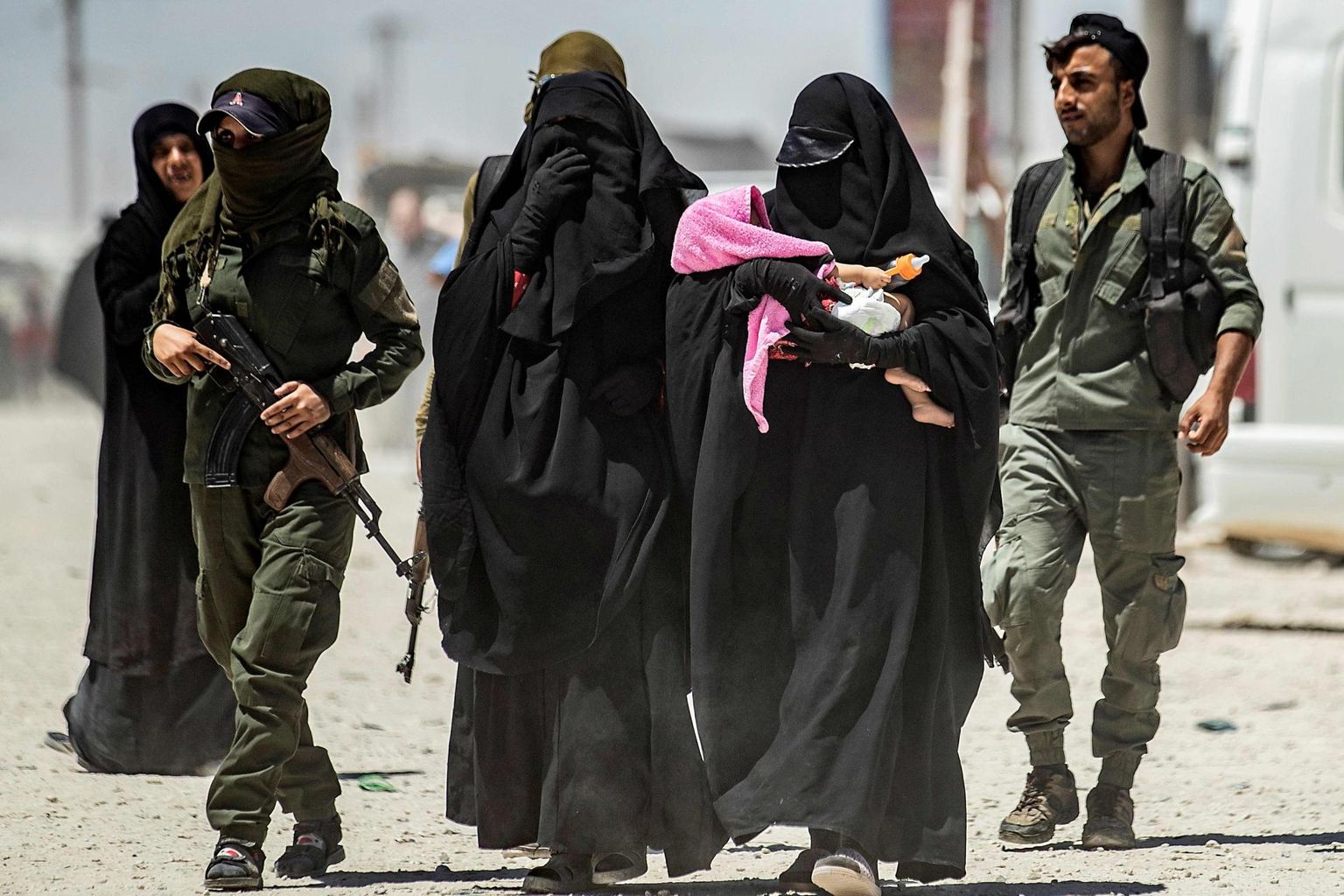 Kurdi võitlejatest valvurid eskortimas al-Holi laagris olevaid ISISe võitlejate naisi.