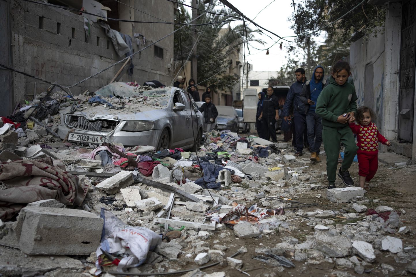 Палестинцы у дома, разрушенного в результате израильского авиаудара в Рафахе.