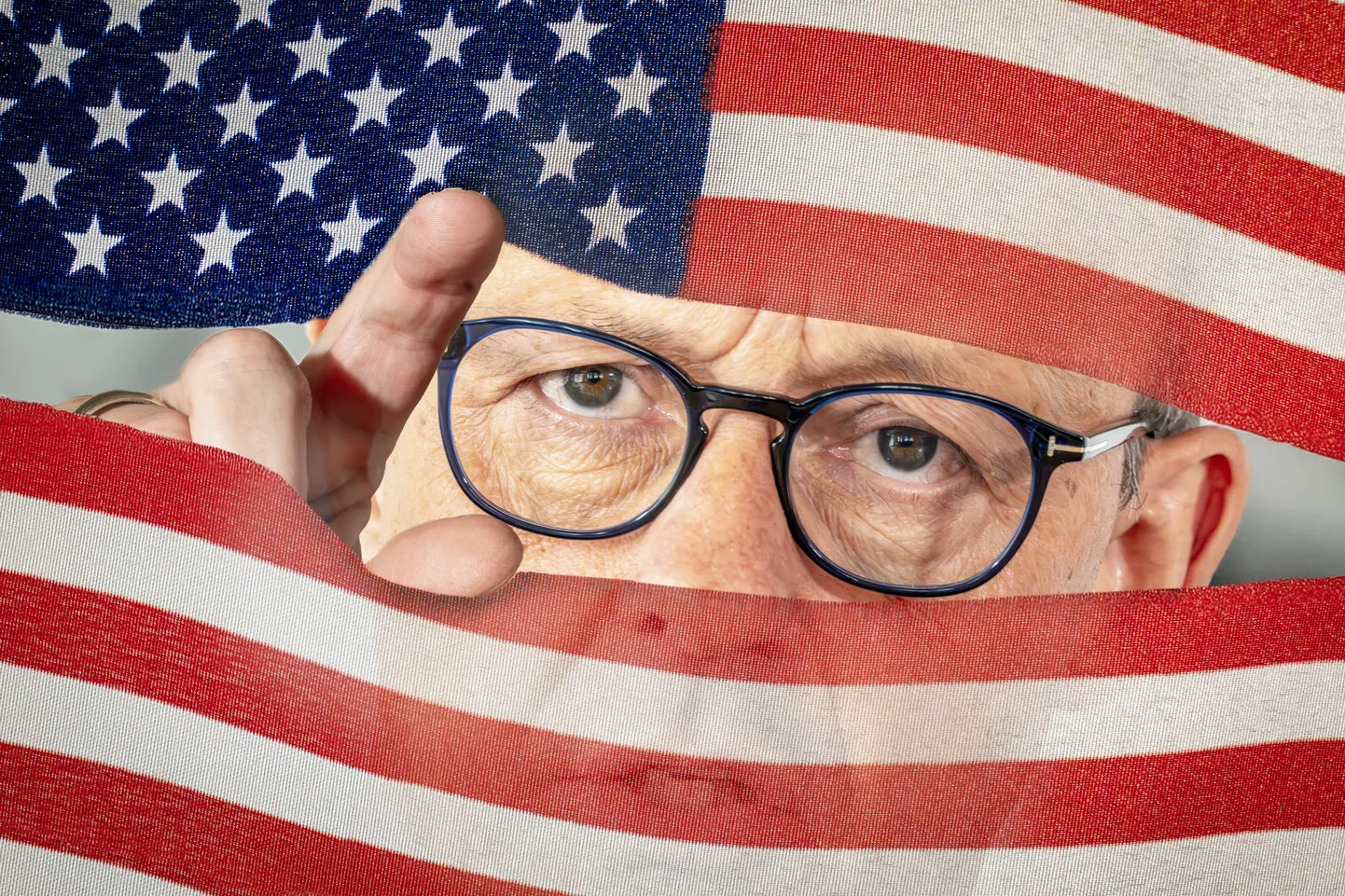 Kantsler Friedrich Merz piidlemas maailma läbi USA lipu. Fotomontaaž Saksamaa meediast.
