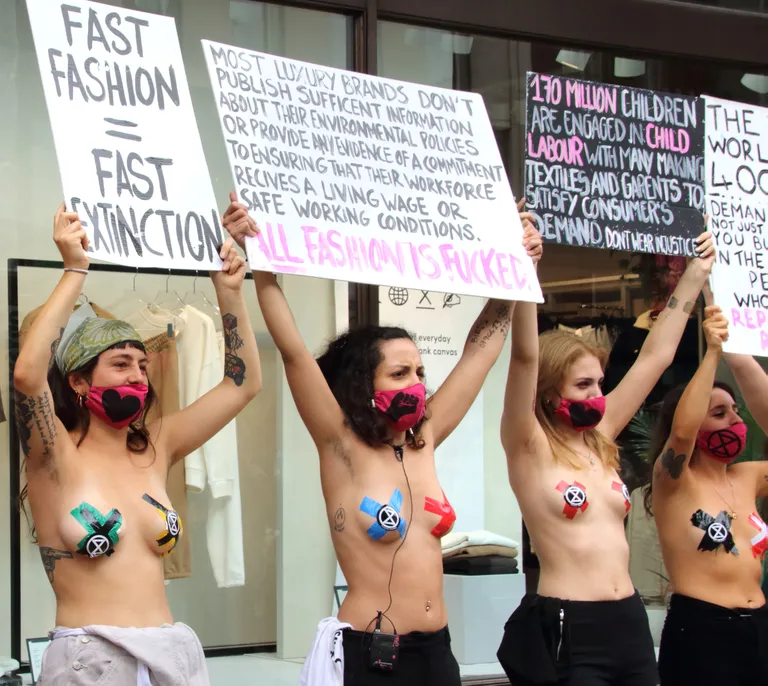 Väljasuremismässu (Extinction Rebellion) protestijad plakatitega «Kiirmood - kiirväljasuremine» ja «Mood kui selline on kurjast» H&M kaubamaja ees Londonis.