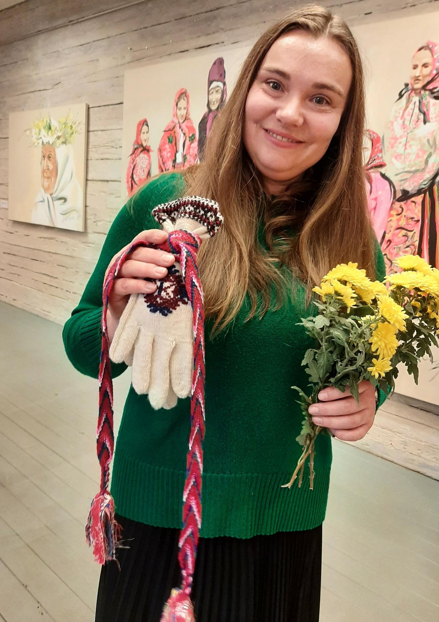 Kunstidisainer ja maalikunstnik Dace Delina Lipska rõõmustas Kihnu muuseumis näituse avamisel talle kingitud roositud sõrmikute ja värvika säärepaela üle.