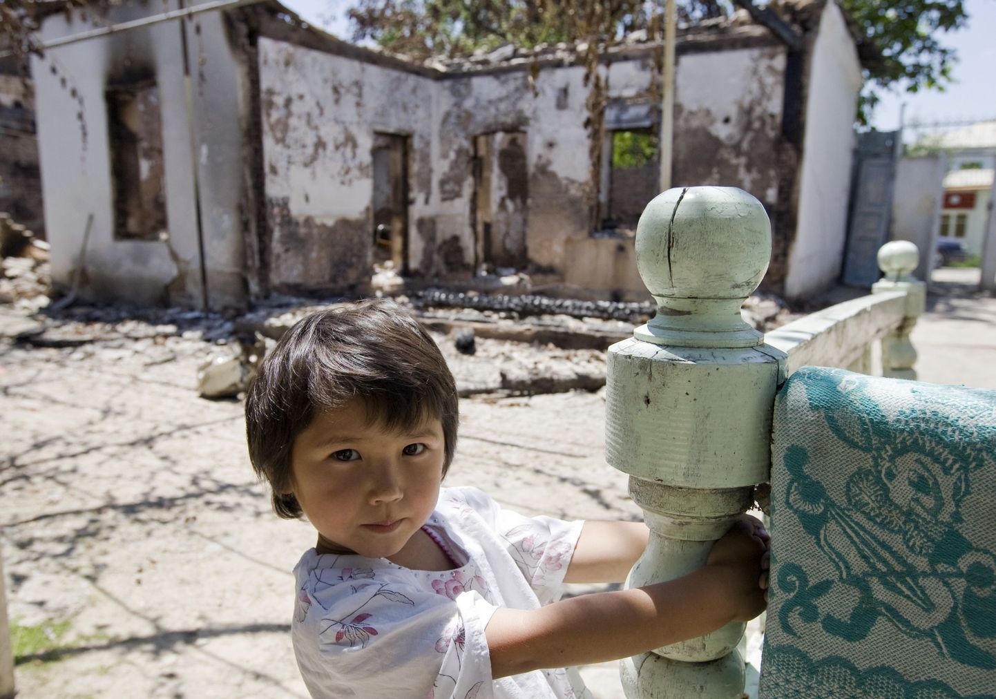 Nelja-aastane usbeki tüdruk Iroda mängib oma pere elumaja juures, mis Ošis sel kuul maha põletati.