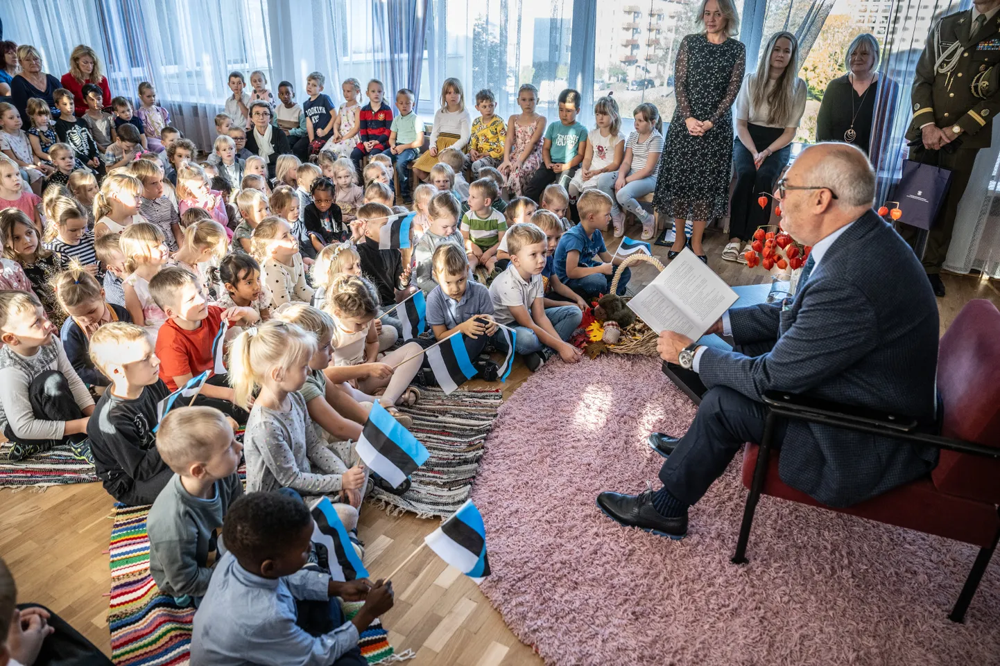 Президент Алар Карис читает книгу малышам.