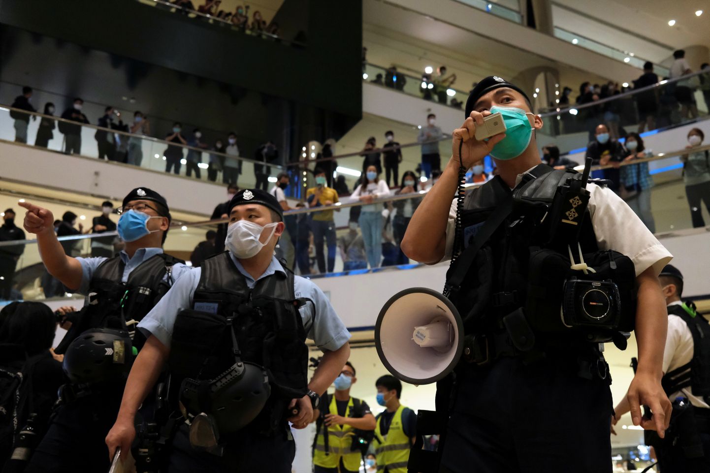 Maskidega politseinikud Hongkongi kaubanduskeskuses valitsusvastaseid meeleavaldusi laiali ajamas.