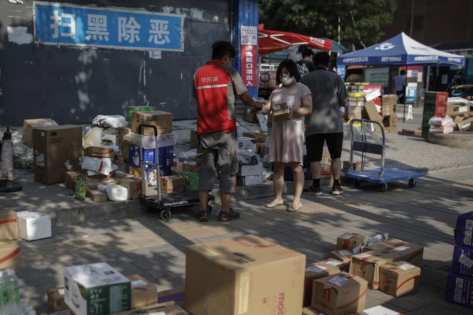 Hiina suuruselt teise veebijaemüüja JD.com töötaja jagab Pekingis klientidele pakke. 