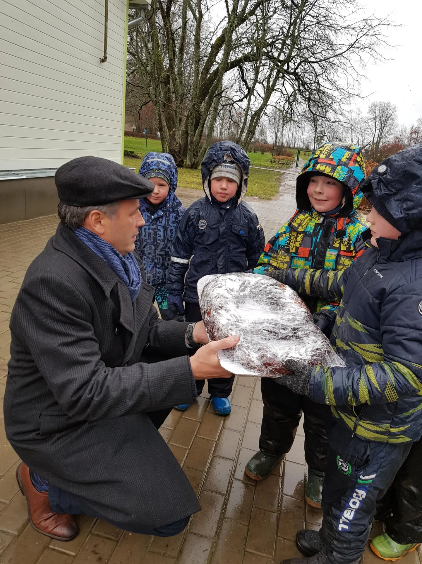 Viljandi vallavanem Alar Karu annab kringli Päikesekiire lasteaia Puiatu õppekoha lastele.
