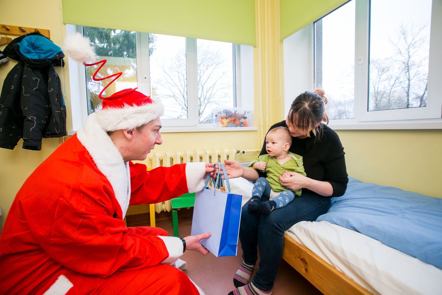 MTÜ Naerata Ometi turundusjuht Gert Karu pooleaastasele Stenile jõulupakki üle andmas.