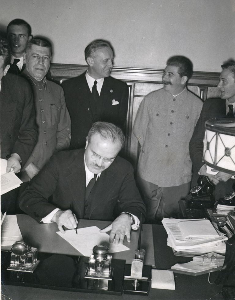 Vjatšeslav Molotov allkirjastab Molotov-Ribbentropi pakti, taamal seisavad Joachim von Ribbentrop ja Jossif Stalin. Foto: Scanpix