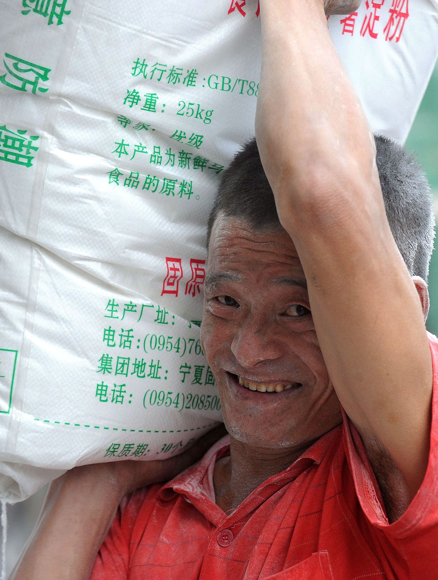 Hiina tööline tassimas jahukotti. Melamiini on leitud ka jahust, mida eksporditi Kõrgõzstani.