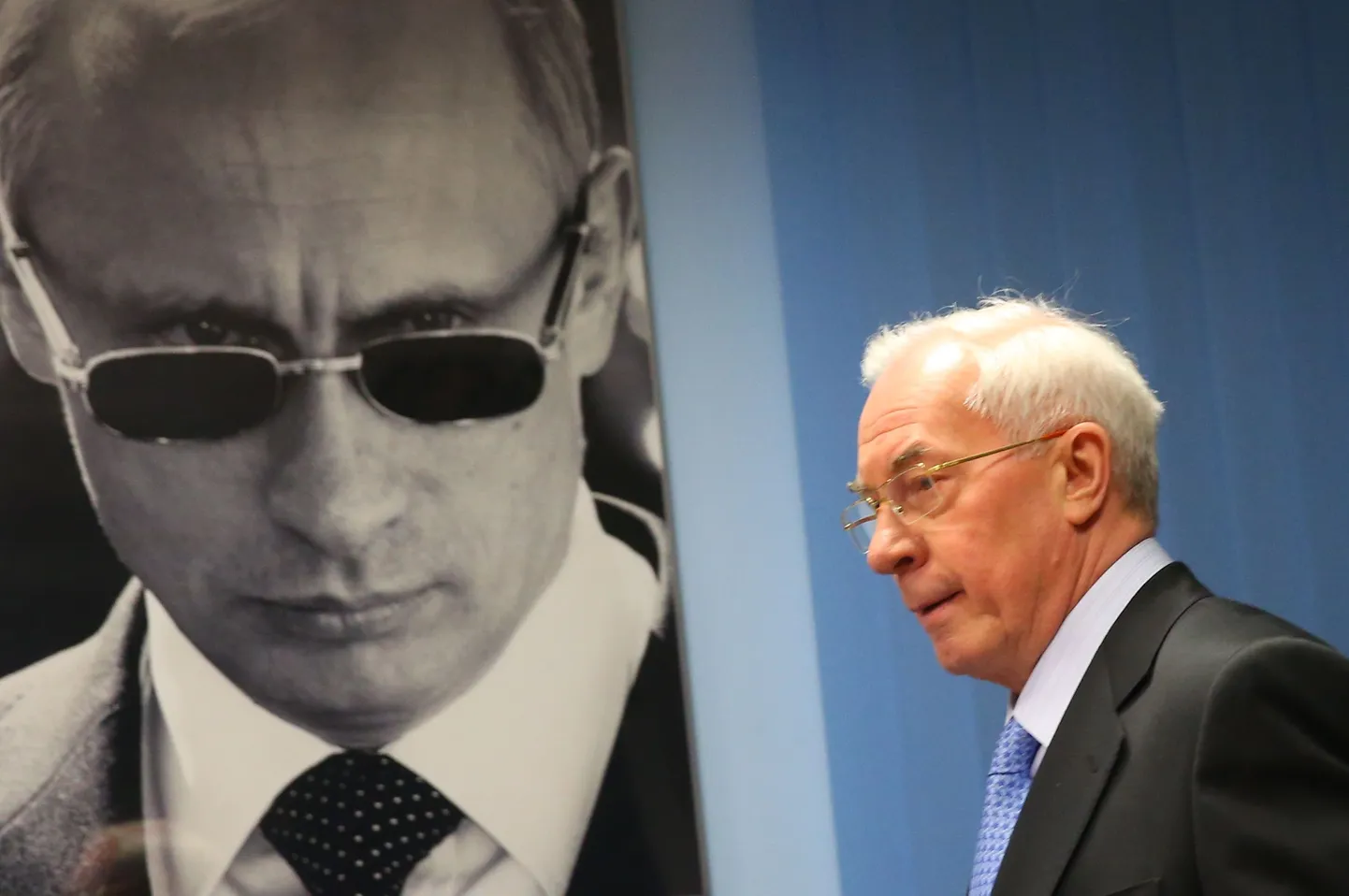 Ukraina endine peaminister Mõkola Azarov. Taustal Vene presidendi Vladimir Putini portree.