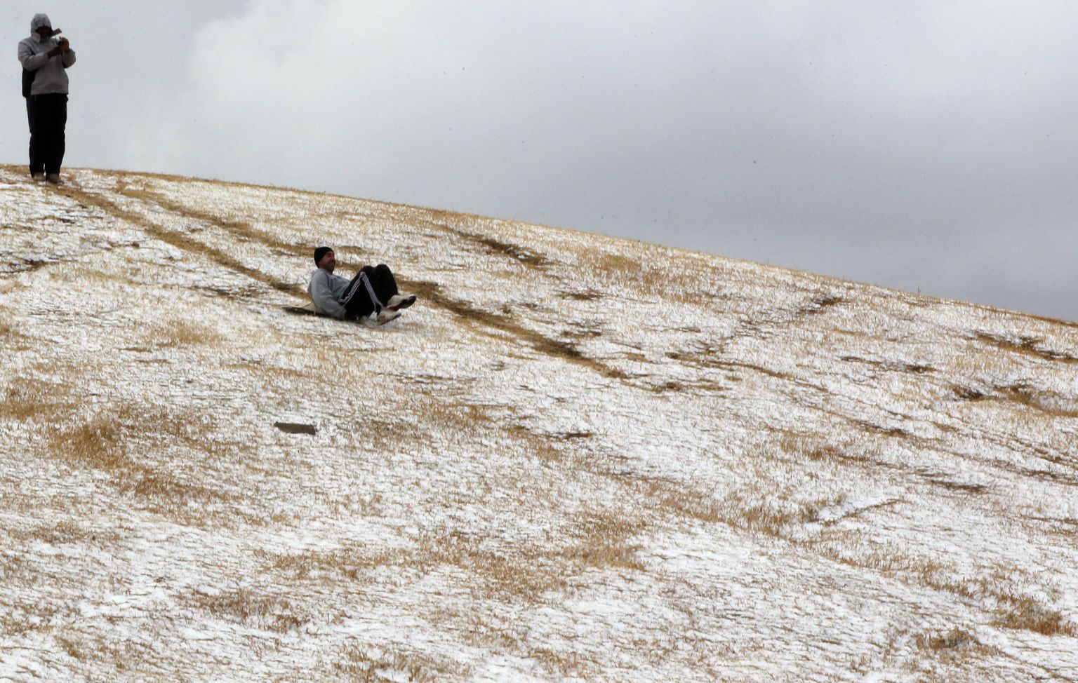 Mees täna Johannesburgis lumisest mäest alla sõitmas.