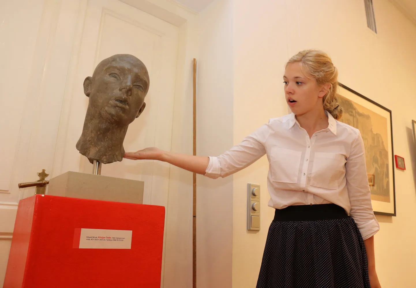 Näituse üks kuraatoreid Hanna-Liis Kont näitab Eduard Wiiralti skulptuuri, mille alumine osa sai kahjustada pommiplahvatuses.