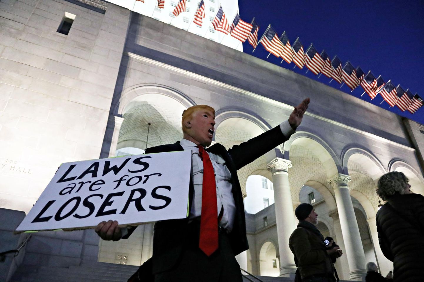 USA presidenti Donald Trumpi kujutavas maskis mees Los Angelese linnavalitsuse juures avaldab meelt riigipea tagandamata jätmise pärast. Silt tema käes teatab «Seadused on luuseritele». 