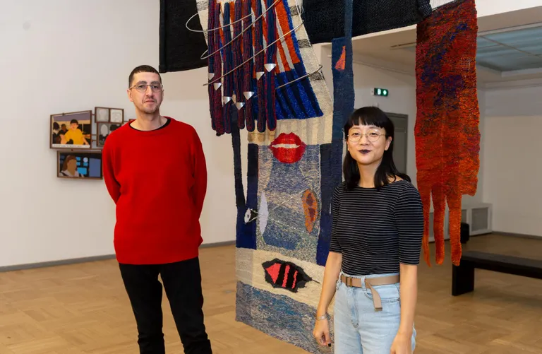 Kuraatorid Niels Van Tomme ja Christine Sun Kim Tallinna Kunstihoones. Esiplaanil Erika Tammpere teos «Näen, mida kuulen».