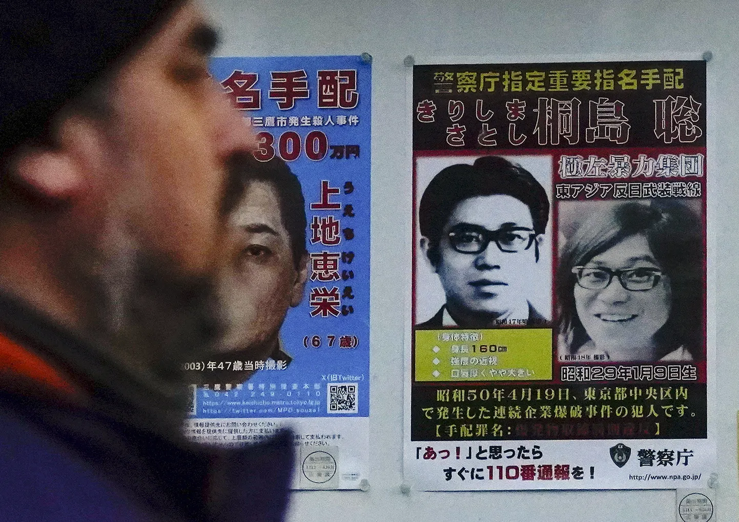 Satoshi Kirishima (paremal) tagaotsitavate plakatil.