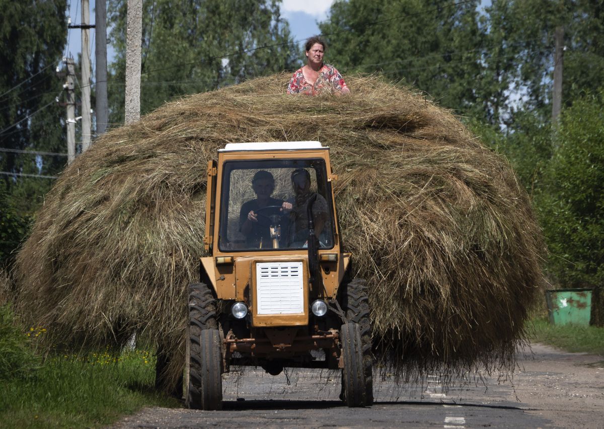 Traktors ved sienu Krievijas ciematā.
