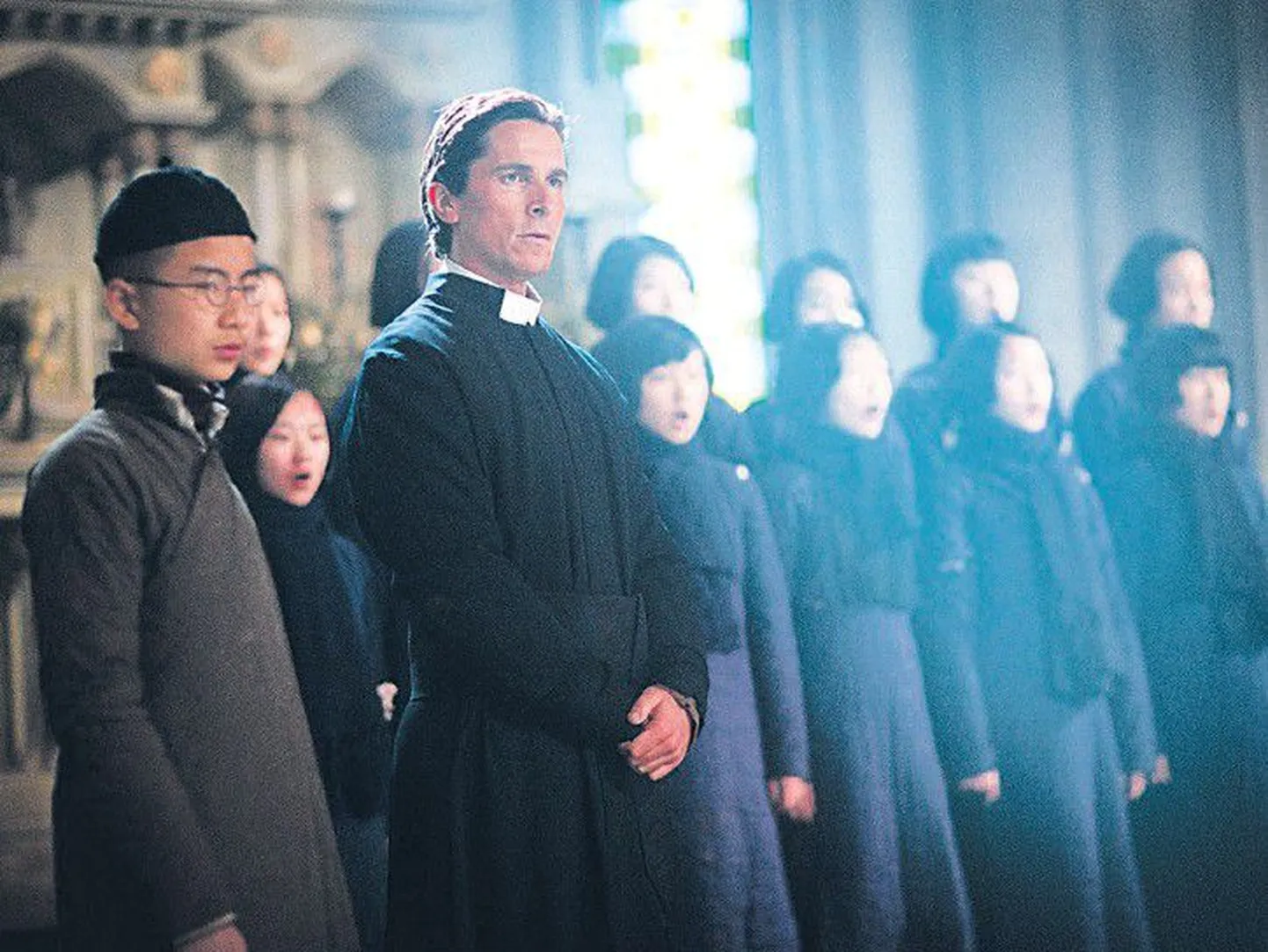 Служка Джордж Чен (Таньюан Хуанг) и похоронных дел мастер Джон Миллер (Кристиан Бэйл) с монастырским хором.