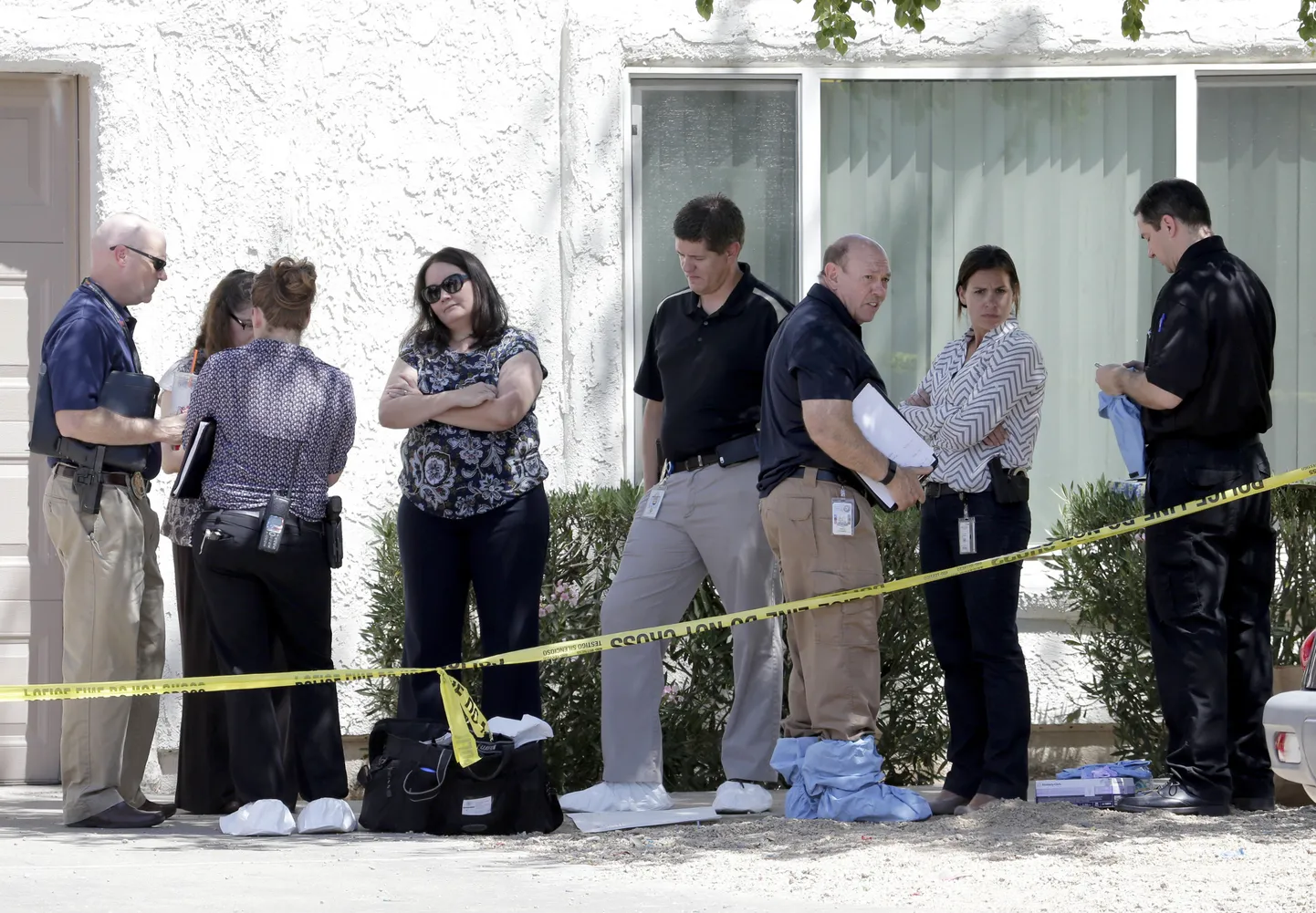 Uurijad Phoenixis maja ees, kus ema tappis oma kolm last ja vigastas ka iseennast.