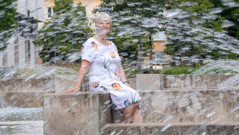 Vene keele ja kirjanduse õpetaja Ludmilla Demidenko palus end pildistada Juri Lotmani mälestusmärgi ja Tartu ülikooli raamatukogu purskkaevu juures, viibides ühekorraga nii päikeses kui vihmas.