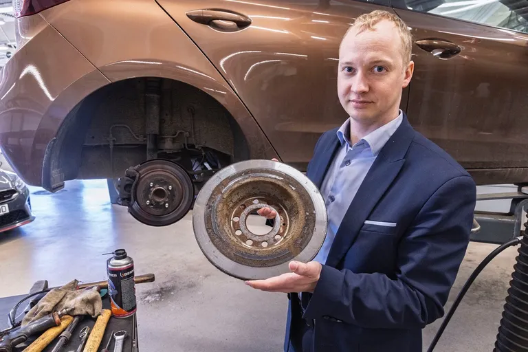 Руководитель по послепродажному обслуживанию Topauto Ристо Сейлер показывает тормозной диск, внутренняя часть которого заржавела и деформировалась.