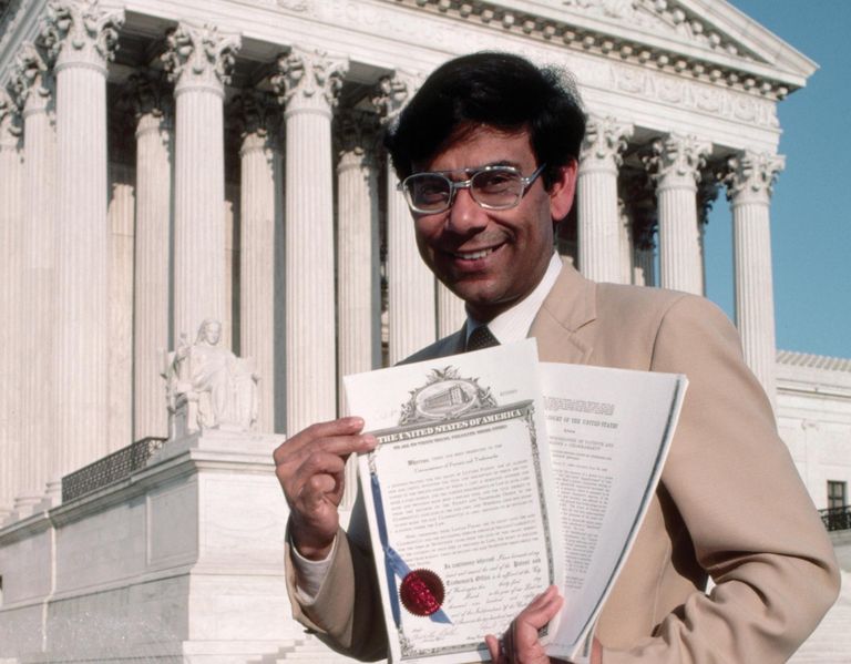 Ananda Chakrabarty USA ülemkohtu hoone ees koos kohtuotsusega, millega kohustati patendiametit talle väljastama patenti elusorganismi loomise kohta.