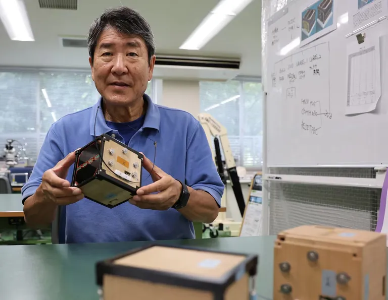 Endine astronaut ja Kyoto ülikooli professor Takao Doi puidust satelliidi esitlusel.