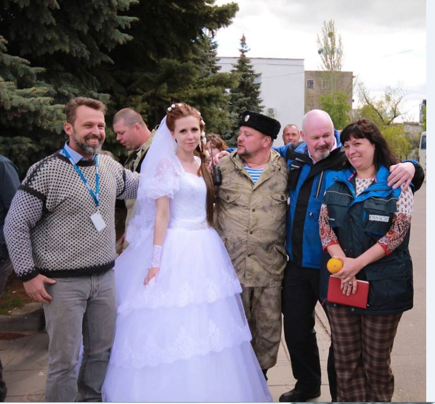 OSCE vaatleja (vasakul) pulmalistega poseerimas.