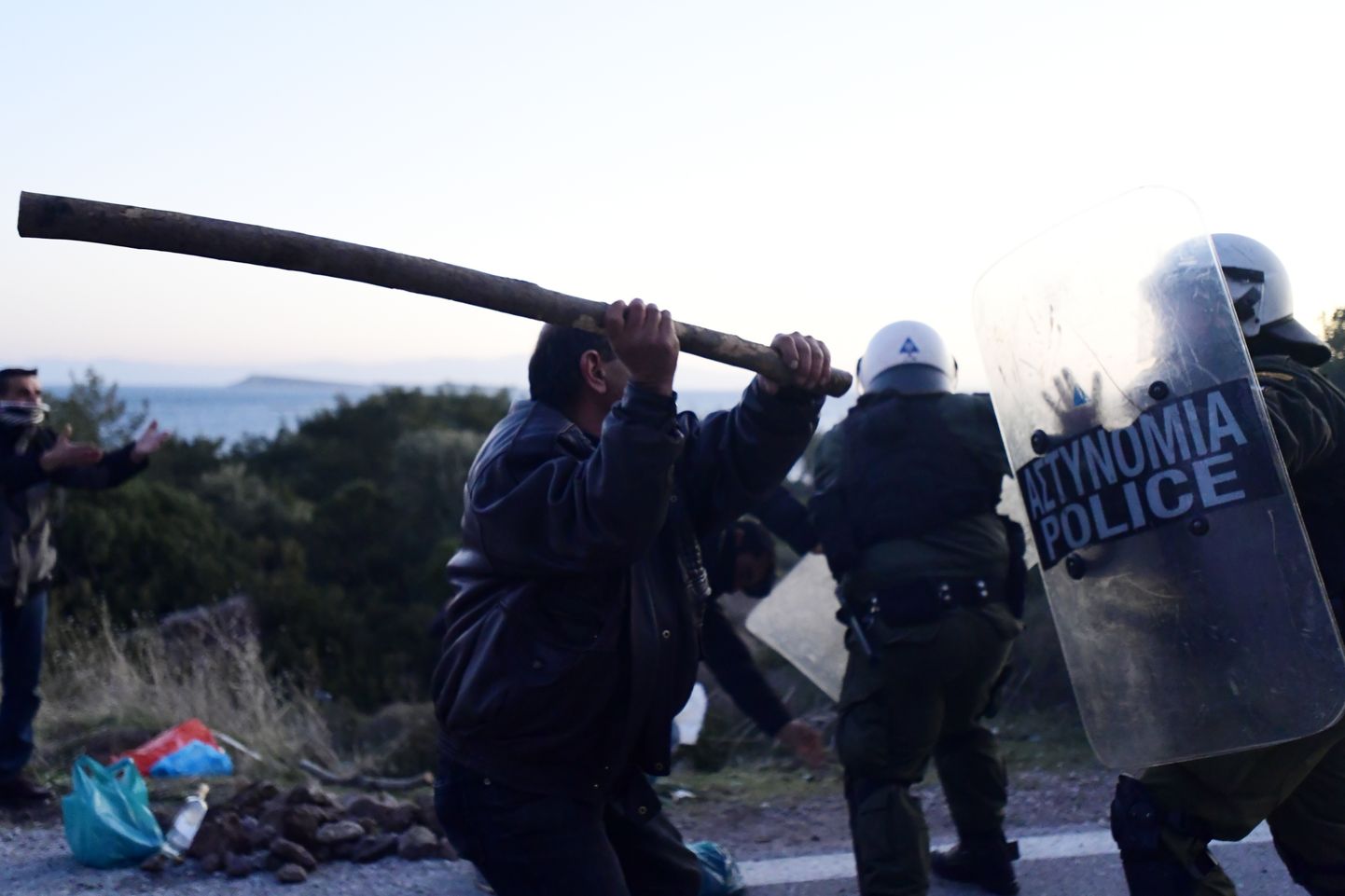 Kohalik elanik Lesbose saarele paigutatud märulipolitseid ründamas.