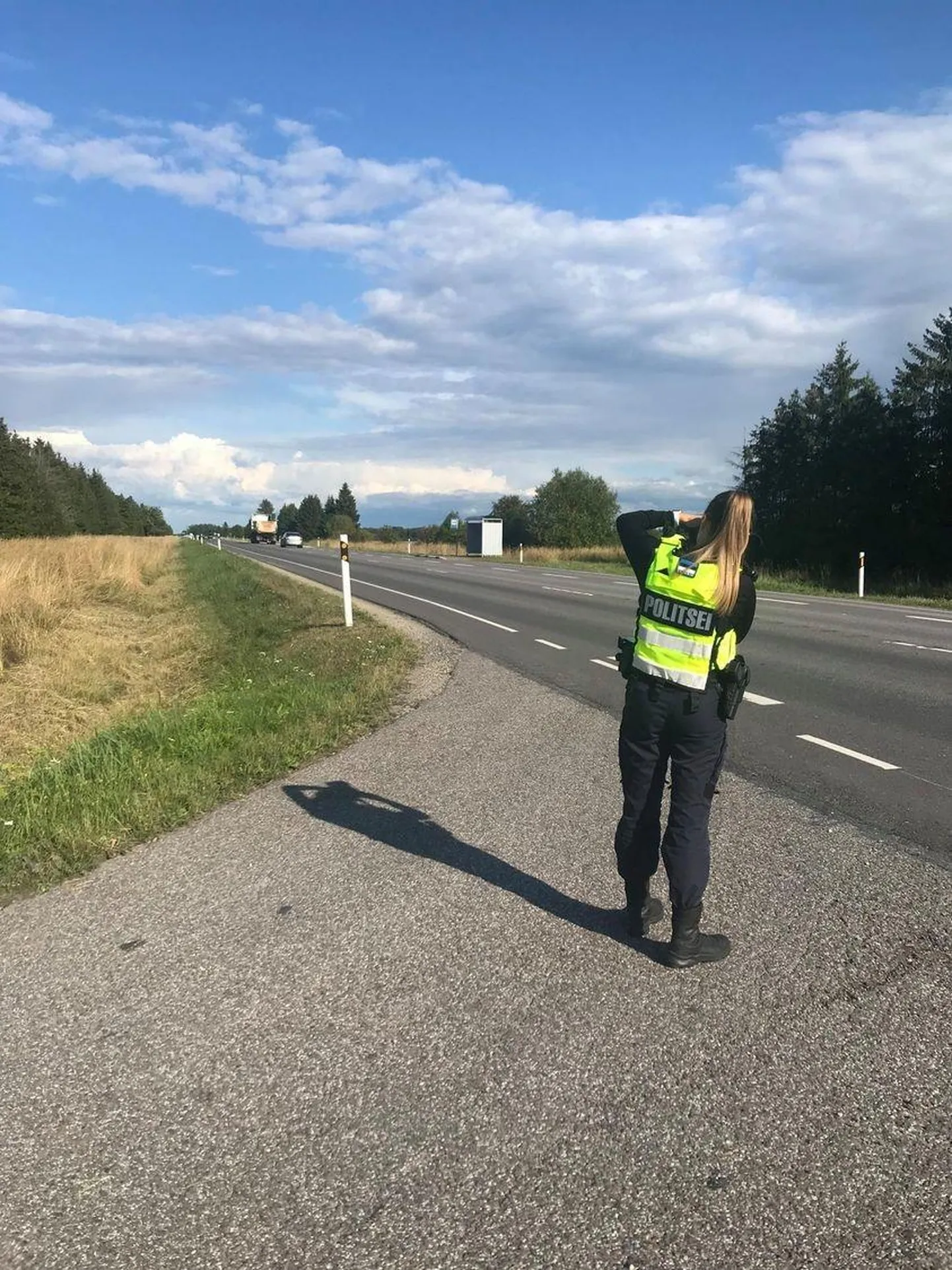 Politseinik sõidukite kiirust mõõtmas.
