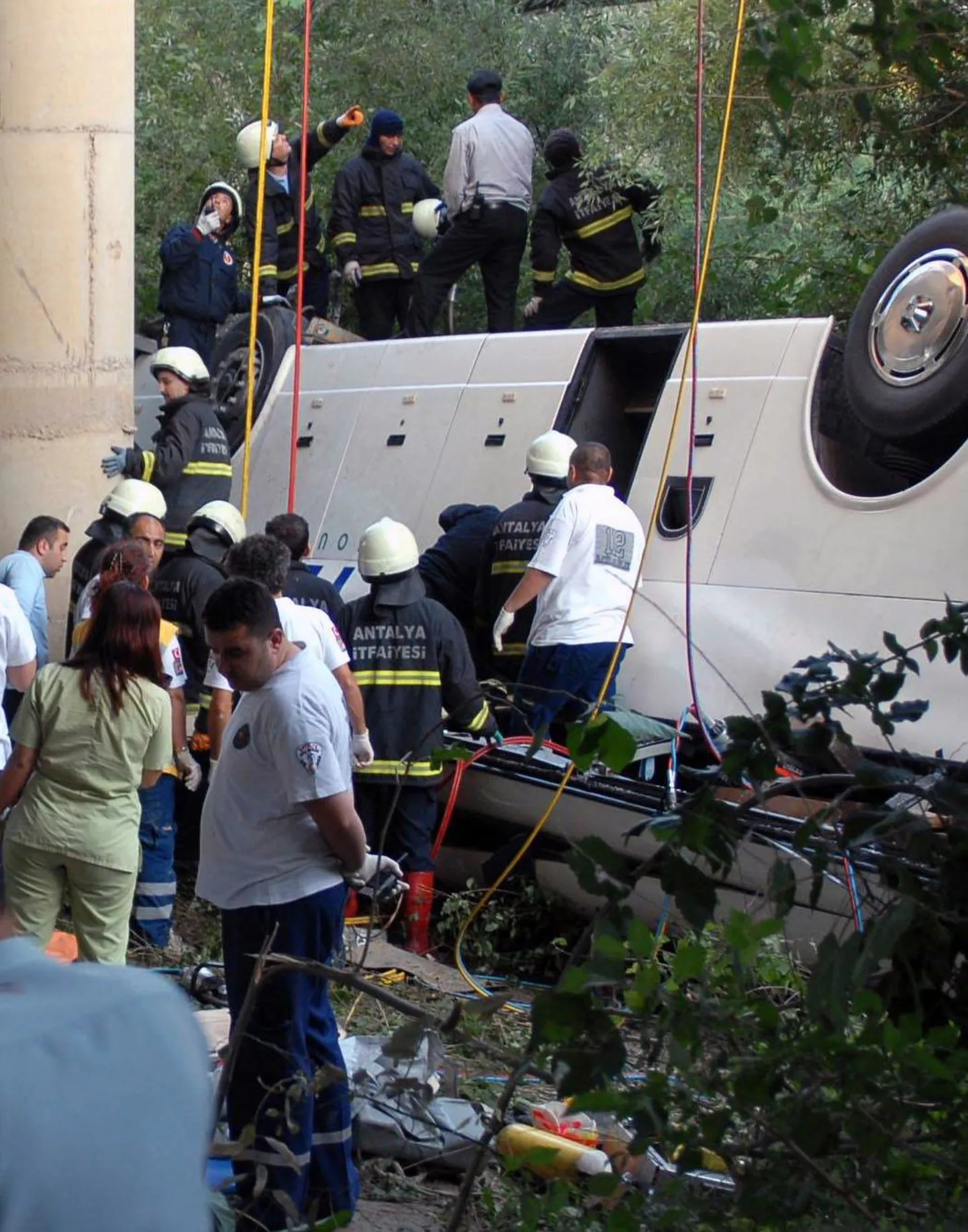 Турецкие спасатели ищут людей в потерпевшем аварию автобусе.