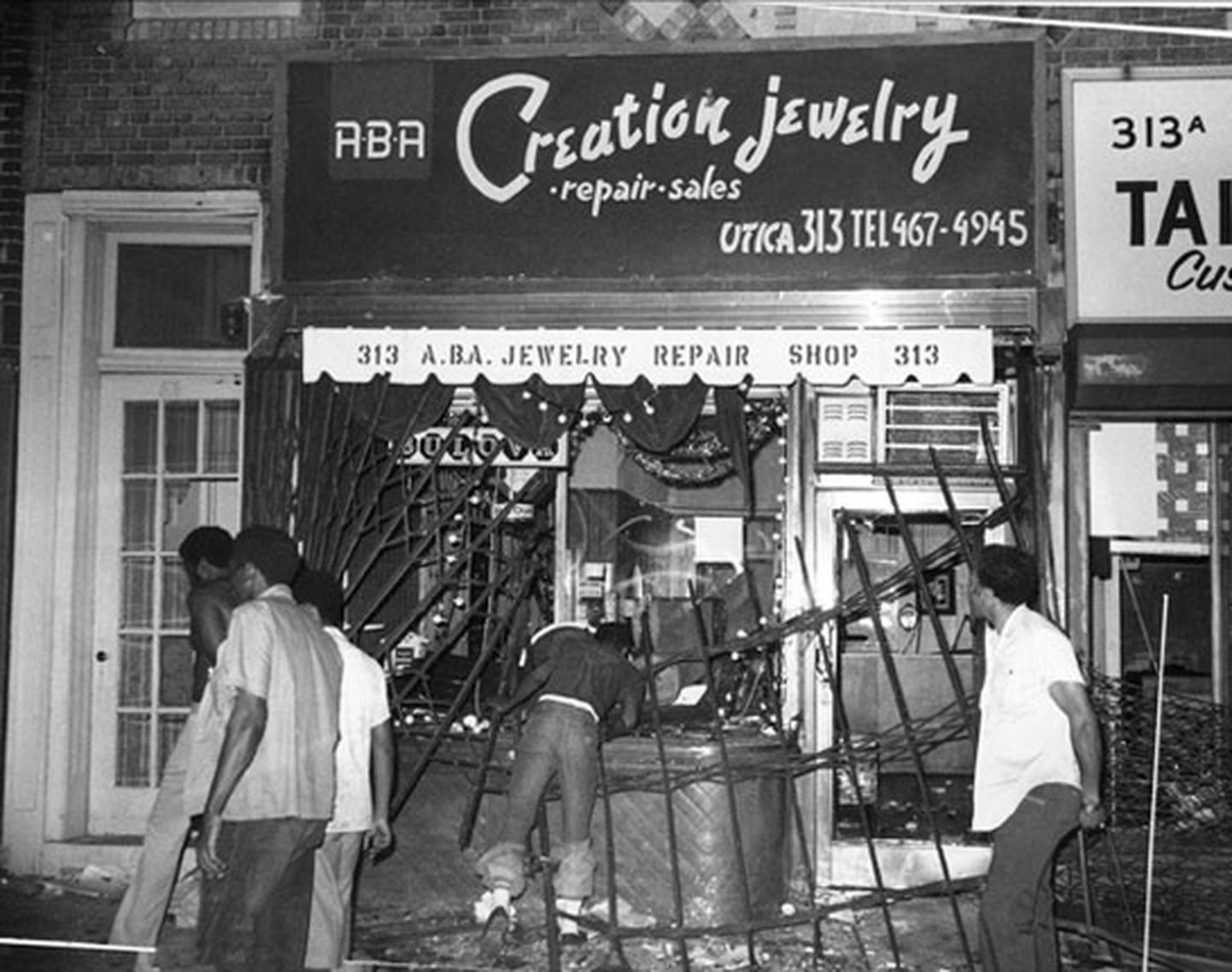 Mees krahmamas ehteid katkilöödud kaupluseaknast New Yorgi elektrikatkestuse ajal 1977. aasta juulis.