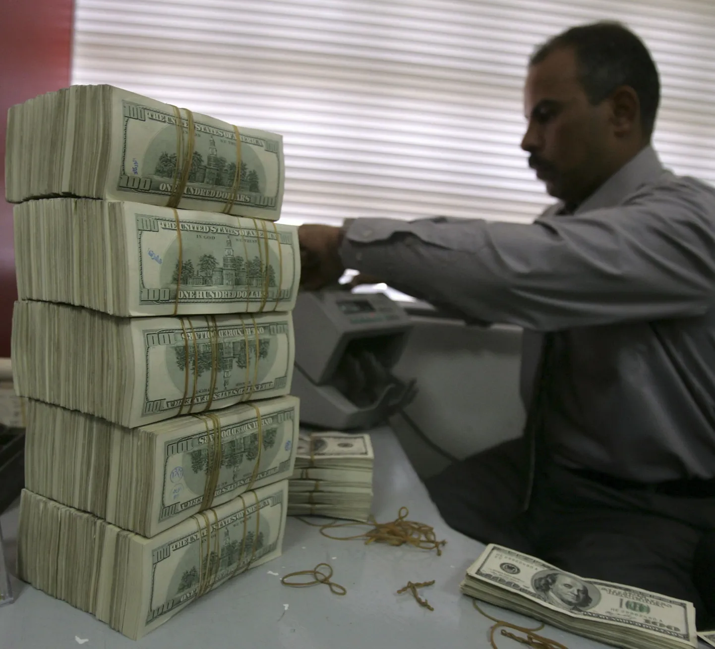 Mees asetab USA dollareid loendurisse.
