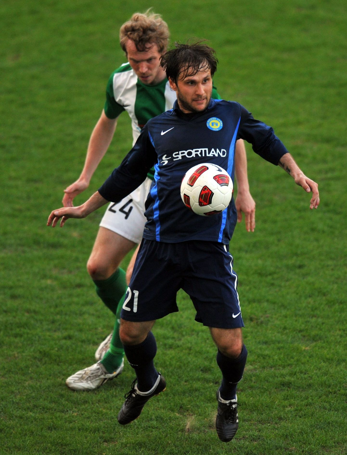 Игрок "Транса" Максим Базюкин (в синей форме) и игрок "Флоры" Карл Палату.