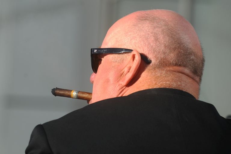 Vīrietis smēķē cigāru.