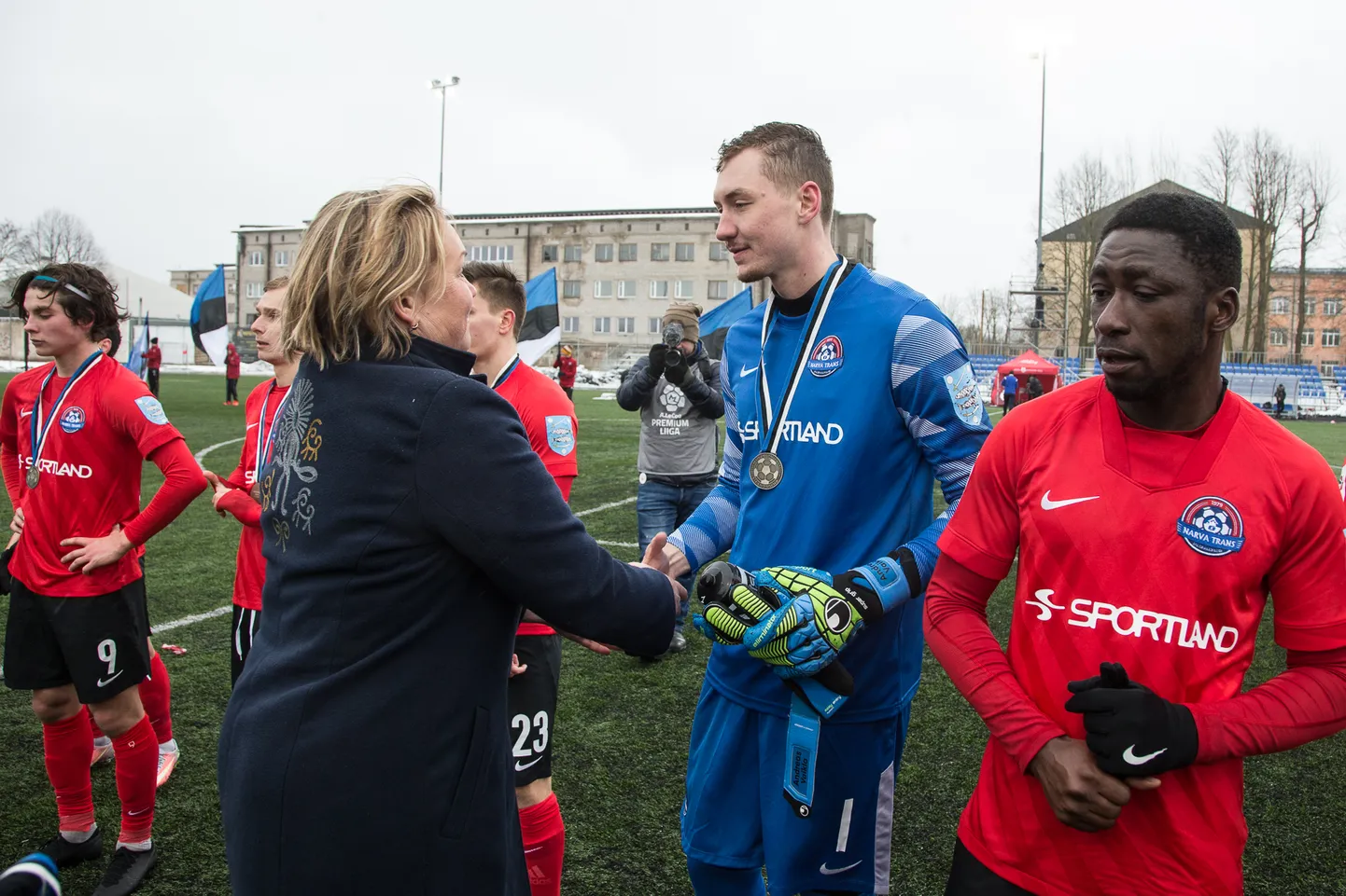 311575 
Pühapäeval Narvas toimunud superkarikafinaali järel pani Narva Transi mängijatele hõbemedalid kaela integratsiooni sihtasutuse tegevjuht Irene Käosaar. See jalgpallimeeskond on omalaadne lõimumise polügoon, kus ühe hooaja jooksul peavad üksteisemõistmise leidma seitsmest riigist Narva saabunud vutimehed. Pildil surub Irene Käosaar kätt Kanada väliseestlasel Andreas Vaiklal, tema kõrval on Ghanast pärit kaitsja Ofosu Appiah.