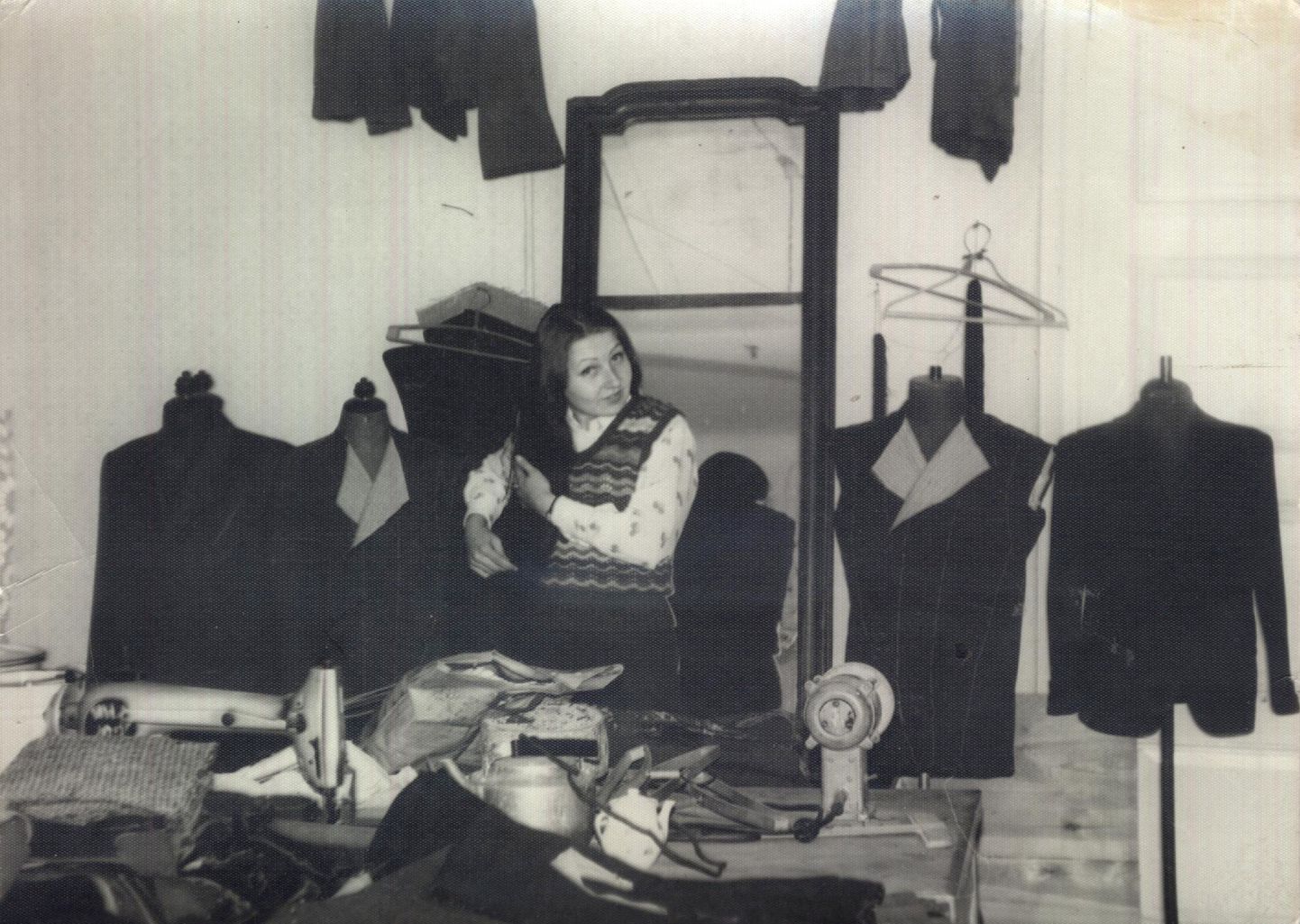 VOJENTORGI ÕMBLUSATELJEE: 1975. aastal tehtud fotol on Anne Raamat oma töölaua taga. Juhuse tahtel on tema selja taga olevate mannekeenidel ainult tsiviilülikonnad, ei ühtegi vormikuube.
3x Erakogu