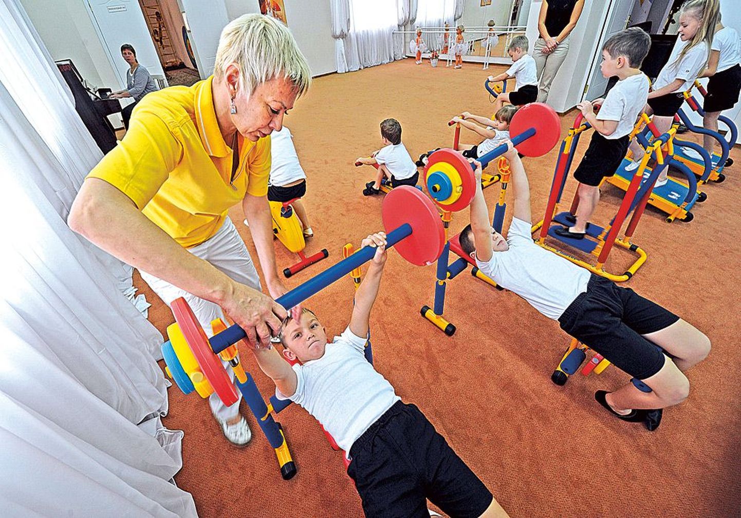 Дети тренируются в атлетическом зале детского сада. По мнению специалистов, в юном возрасте следует заниматься различными тренировками, не концентрируясь на каком-то одном виде спорта.
