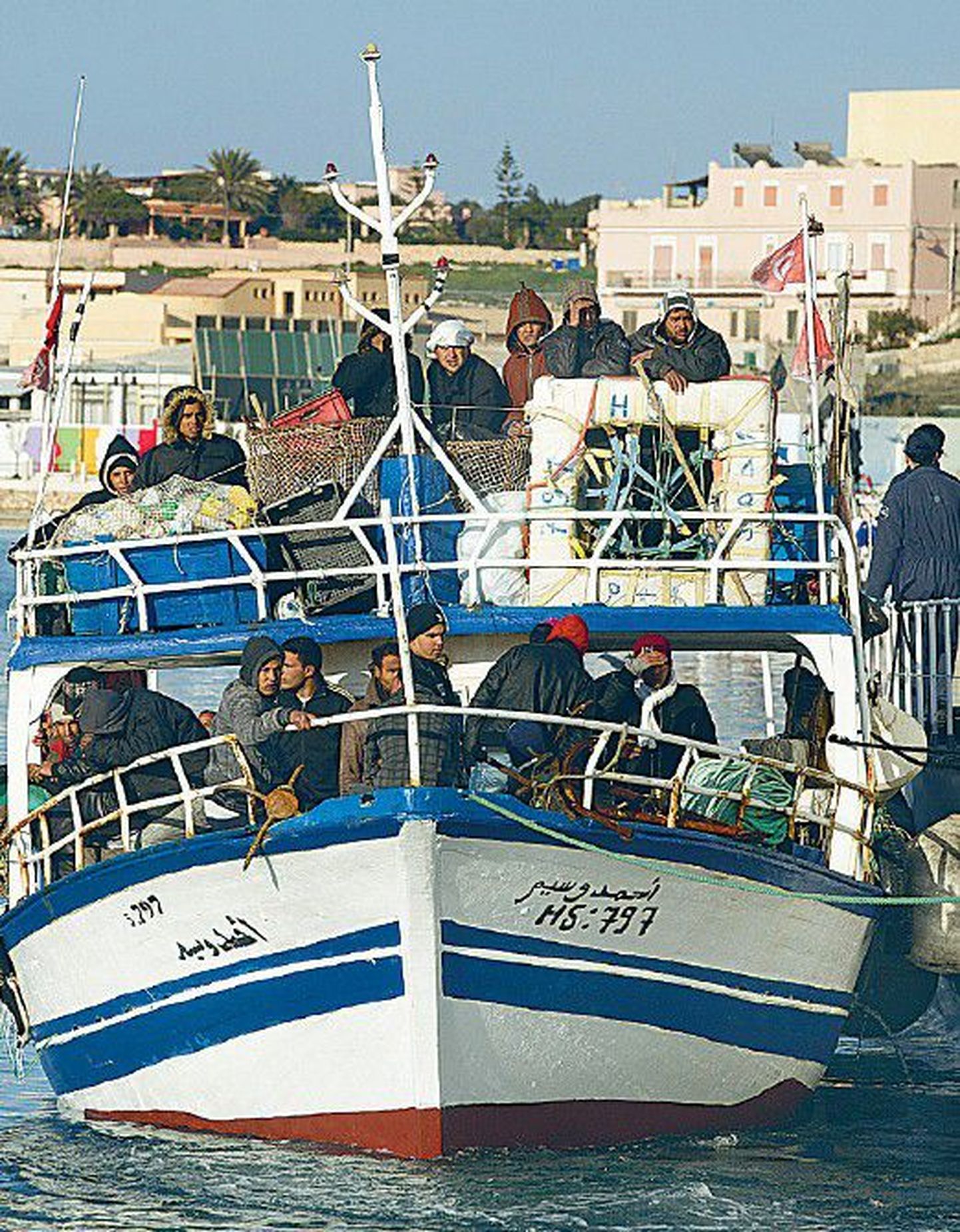 Тунисские беженцы массово прибывают на лодках в Италию.