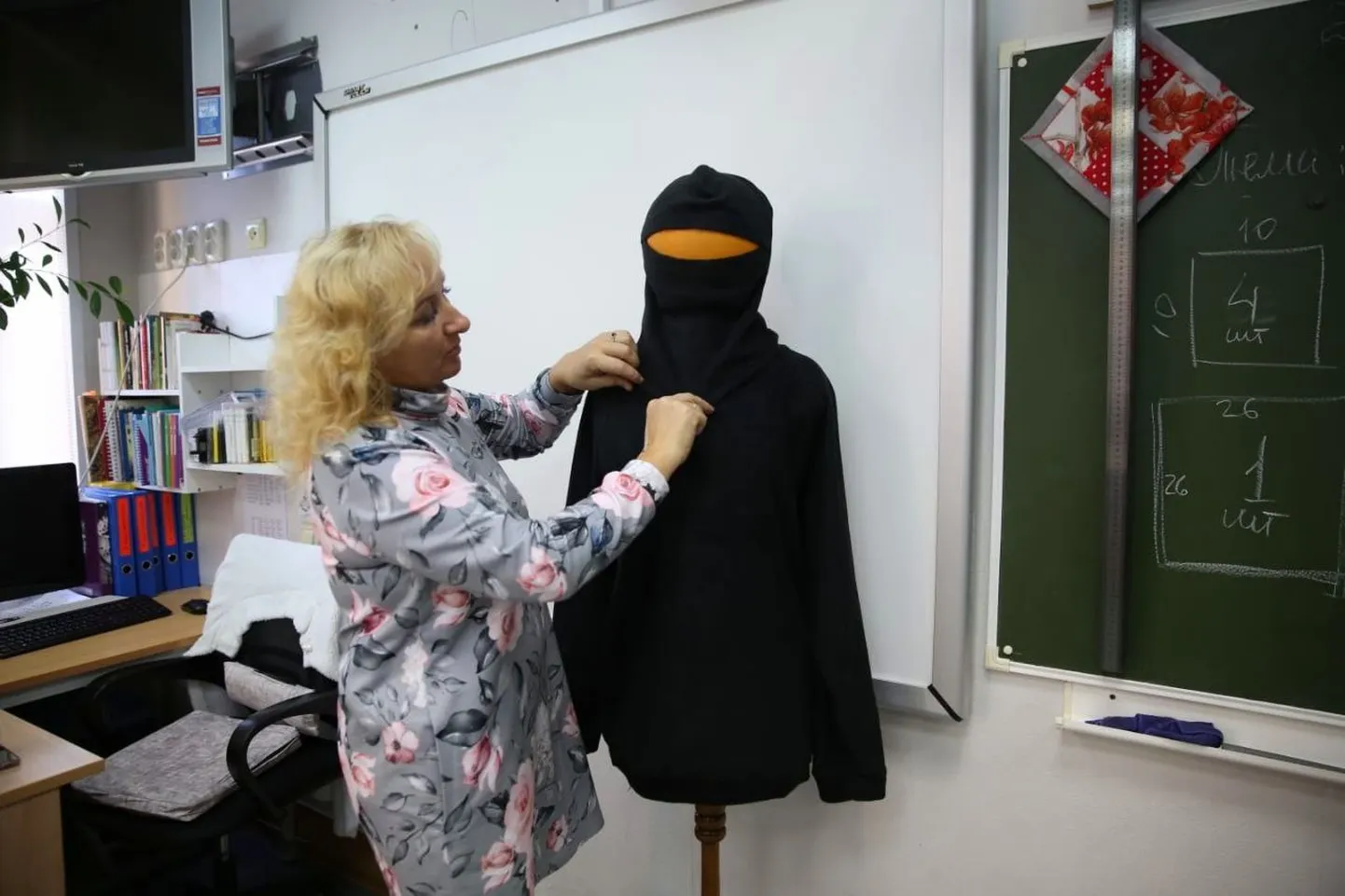 Учитель показывает, как шить форму для российской армии