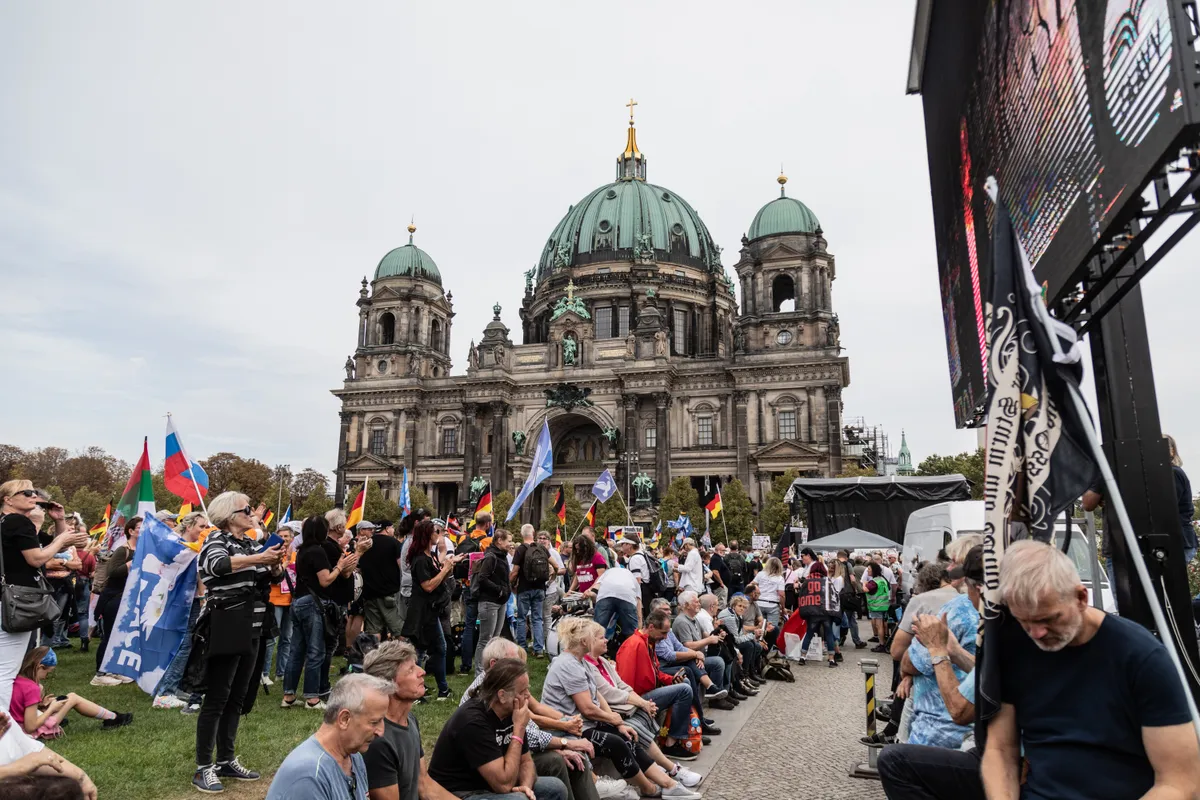 Supporters of the far right party AfD (Alternative for Germany) gather and hold German and AfD party flags in front of the Berlin Cathedral on the 33rd anniversary of German Unity Day.