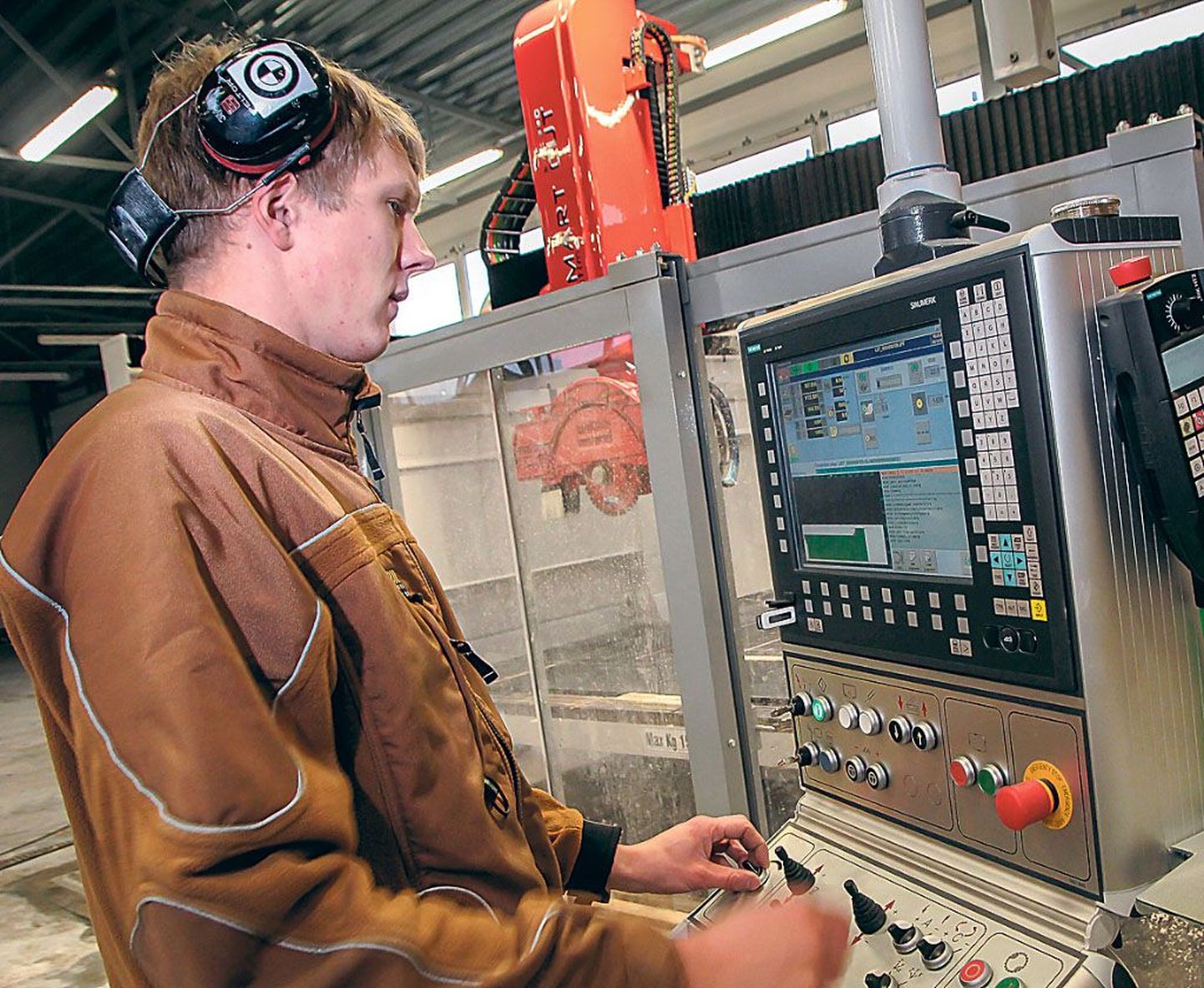 Edelsteini tootmistöötaja Janary Valm näitab, kuidas moodne CNC-saag töötab. Mõni nupule vajutus arvutis ja Valmi selja taga paiknev masin lõikabki soovitud formaadis kivi välja.