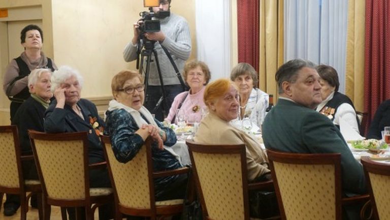 Внимательно слушают российского посла ветераны за праздничным столом 